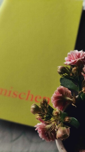 An issue of Mischen magazine behind a small bouquet of flowers.