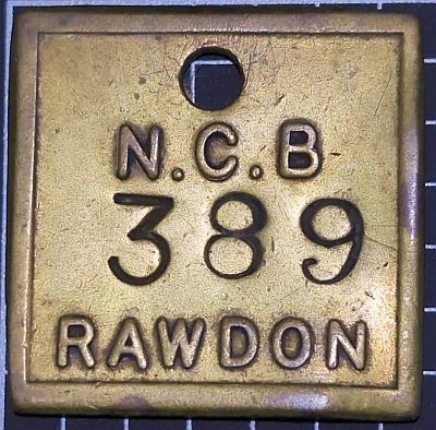 Square brass token with text: N.C.B 389 RAWDON (The number was stamped later)