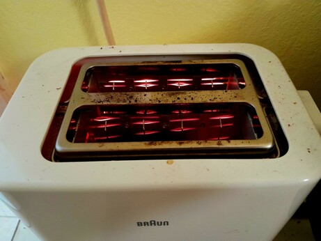 Filaments glow as toast toasts in the toaster, round side down.