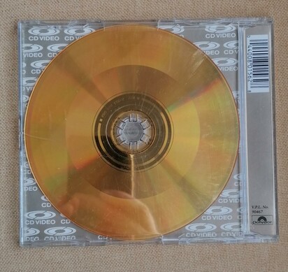 Rear of cd jewel case. Transparent showing gold cd. Distinct banding to show different encoded tracks can be seen