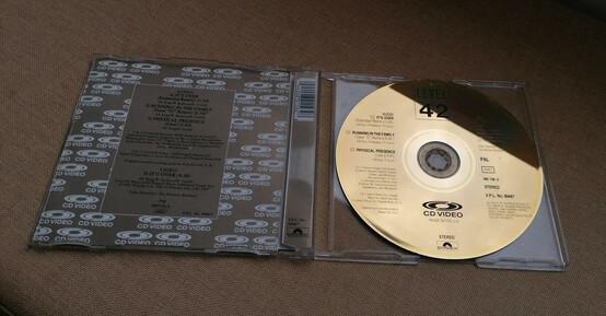 Opened cd jewel case. Booklet on the left, gold cd on the right.