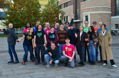 Group picture of people, many of them wearing Free Software shirts, some of them doing things that are supposed to be funny ;)