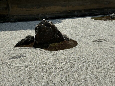 Rock garden detail, one large rock sitting on some gravel.