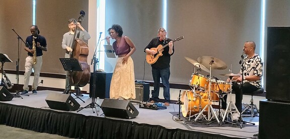 A jazz band with clarinet, upright bass, guitar, drums and a singer.