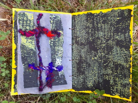 #15 The last page is a collage of a double cross of silk threads in a red- and blue mixture (the stitches backside are on '14). The fibre crosses connect 2 columns of the black printed paper. The right is the cover cardboard covered with black tissue paper. Printed in white and yellow with maize cobs.