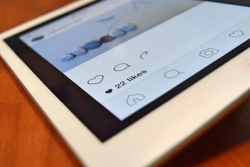 Tablet, schräg fotografiert, so dass man nur sieht, dass dort ein Instagram-Post mit 22 Likes aufgerufen ist.