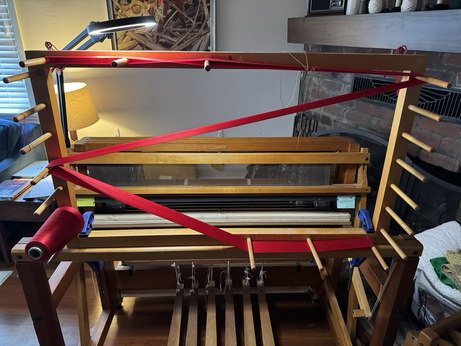 This is my wooden warping frame with 500 2/60 red silk threads on it. They are run back and forth three times to measure three yards