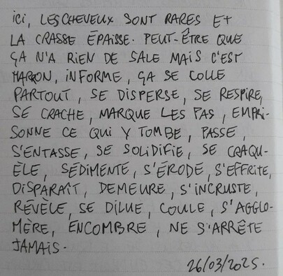 À l'image : une page de carnet avec des lignes sur laquelle est écrit au stylo et en lettres capitales le poème suivant : "ICI, LES CHEVEUX SONT RARES ET LA CRASSE ÉPAISSE. PEUT-ÊTRE QUE ÇA N'A RIEN DE SALE MAIS C'EST MARRON, INFORME, ÇA SE COLLE PARTOUT, SE DISPERSE, SE RESPIRE, SE CRACHE, MARQUE LES PAS, EMPRISONNE CE QUI Y TOMBE, PASSE, S'ENTASSE, SE SOLIDIFIE, SE CRAQUÈLE, SÉDIMENTE, S'ÉRODE, S'EFFRITE, DISPARAÎT, DEMEURE, S'INCRUSTE, RÉVÈLE, SE DILUE, COULE, S'AGGLOMÈRE, ENCOMBRE, NE S'ARRÊTE JAMAIS."