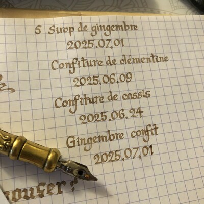 Test d'écriture pour sirop de gingembre, confit et des confitures maison, avec la date de mise en pot sur du papier petits carreaux avec une plume biseautée taille 4