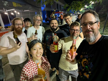 A group of people with various beers and non-alcoholic drinks in a park