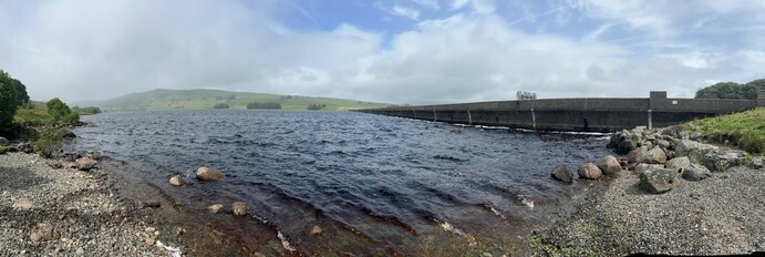 The view from the shore - Sleddale reservoir at the dam under a blue sky with cloud coming in