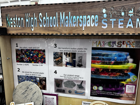 A board showing the plastic recycling process, and some brightly coloured coasters