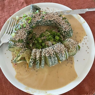 Foto - Teller mit einer spiralförmig aufgeschnittenen Gurke ... die Gurke wurde vorher in einer Tahin-Sauce (mit Chili) mariniert und ist mit Sesam sowie Frülingszwiebel garniert ...