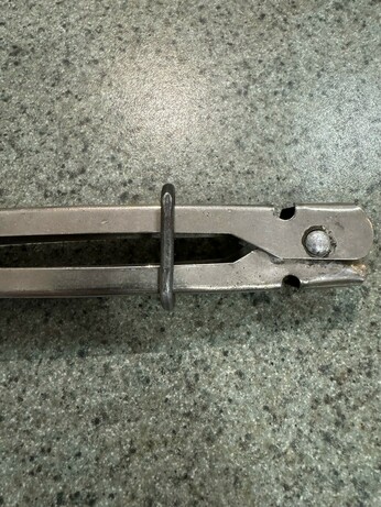Close-up of the new fencing wire tong clip holding the tongs shut.