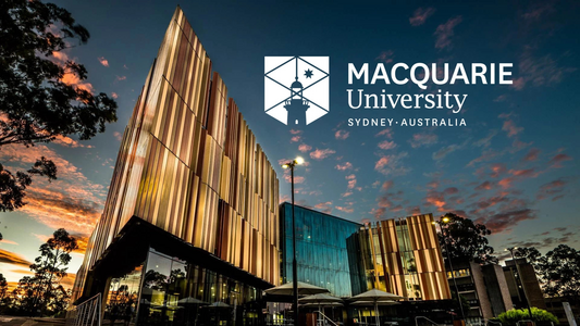 A sharp-edged building that is being imaged from the front facade, whilst the sun has set. The words "Macquarie University - Sydney Australia" are annotated.