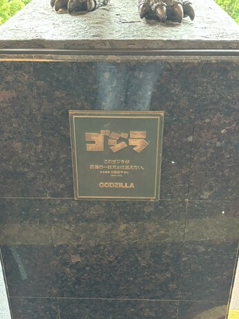 Close up of the metal plaque on the statue’s marble base. It bears the Godzilla movie logo and character Dr. Yamane’s quote in Japanese, with “Godzilla” written in English at the bottom.