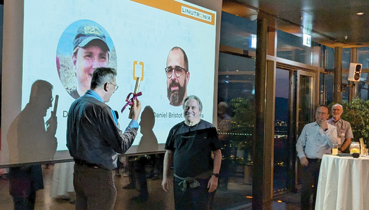 Thomas Gleixner presenting Linus Torvalds with the code of the PREEMPT_RT support patchset in printed form wrapped in gold paper with a ribbon at the Kernel Summit in Vienna, Austria. © Thorsten Leemhuis