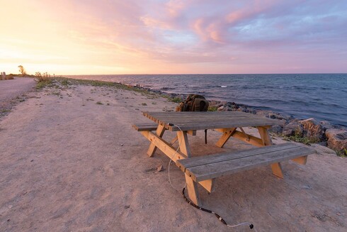 wide angle phtos of the pota spot having a picknick table about 8m away from the water of the baltic sea at sunset time.