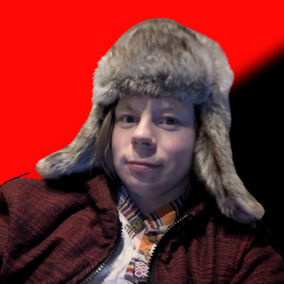 Person in a warm, furry hat and patterned jacket against a bold red and black anarchist background, conveying a cozy yet bold atmosphere.
