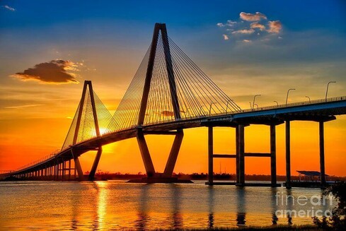 Sunset over the Arthur Ravenel Jr. Bridge near Shem Creek in Charleston, South Carolina, showcasing the bridge's cable-stayed architecture silhouetted against a golden sky reflecting on tranquil waters. This artwork is from the Fine Art Gallery of Shelia Hunt at Shelia-Hunt@pixels.com