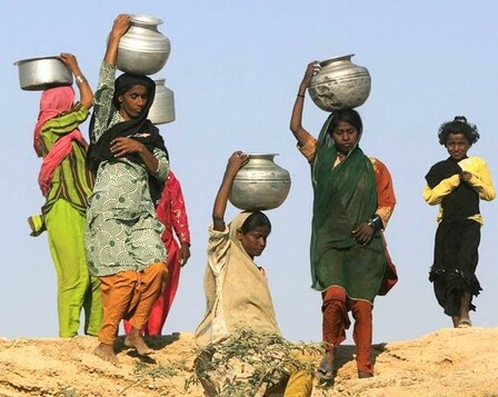 About five different people in the desert! And four are women with big silver jars of water balanced on their heads carrying it home from where they filled them!