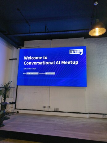 projected screen with welcome message for conversational meetup event