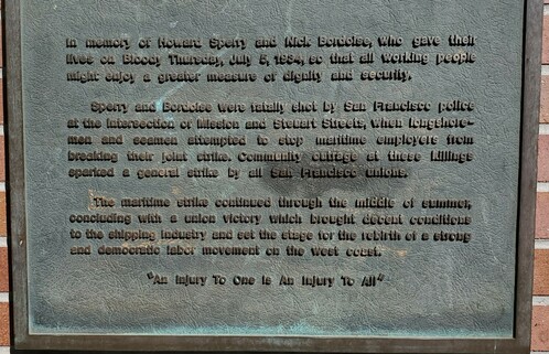 Plaque commemorating the 1934 San Francisco General Strike.

Reads: In memory of Howard Sperry and Nick Bourdoise, who gave their lives on Bloody Thursday July 5, 1934 so that all working people might enjoy a greater measure of dignity and security.

Sperry and Bordoise were fatally shot by San Francisco police at the intersection of Mission and Steuart Streets, when longshoremen and seamen attempted to stop maritime employers from breaking their joint strike. Community outrage at these killings sparked a General Strike by all San Francisco unions.

The maritime strike continued through the middle of summer, concluding with a union victory which brought decent conditions to the shipping industry and set the stage for the rebirth of a strong and democratic labor movement on the west coast.

"An Injury to One is an Injury to All"