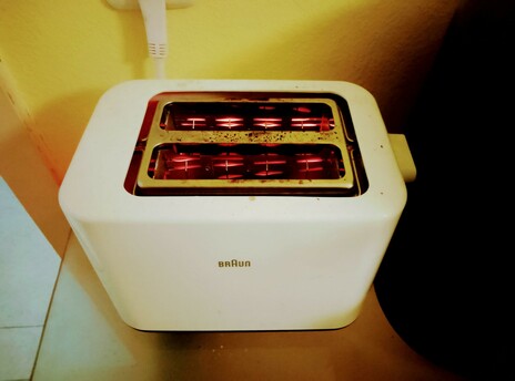 Filaments glow as toast toasts in the toaster, round side down.