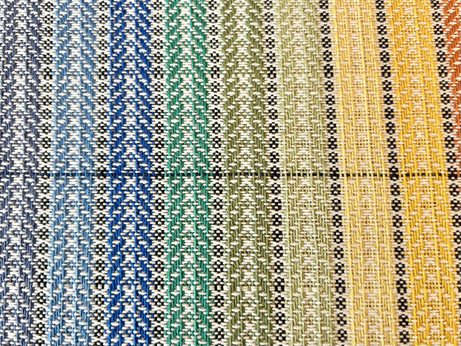 A close up look at some handwoven fabric in a spiral twill pattern