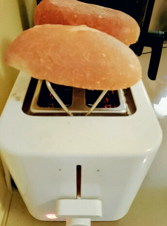 Brötchen toasting on a pop-up rack on the toaster, round side UP!
