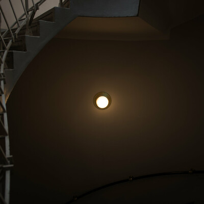 Photo of a light on the wall, in a staircase, inside a house in Prague