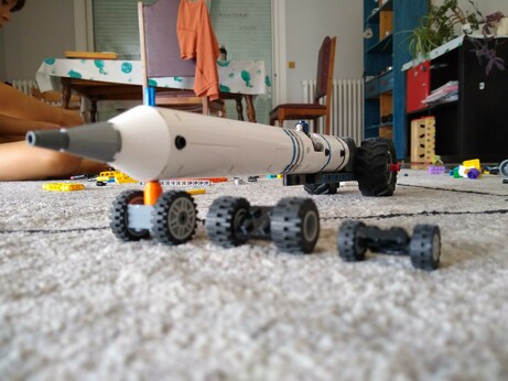 A long rocket on its side with a section cut in half, making a perfect minifig cabin, and the biggest wheels we had, kinda à la a drag race car or Blue Flame.
