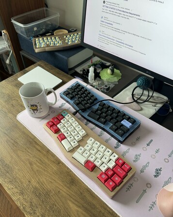 Candid desk shot with 3 of the same weird keyboard while one is being debugged for firmware not working.