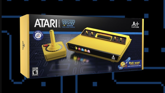 An Atari 2600 and controller just like the original except bright yellow with decal of PacMan being chased by ghosts across the front.