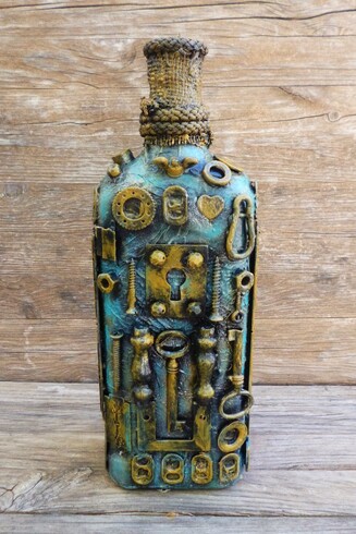 This image showcases a bottle that has been transformed into a captivating piece of art, embodying the steampunk aesthetic. The bottle's surface is richly adorned with a variety of small metal gears, rings, bolts, and mechanical components that are meticulously arranged in a seemingly random yet harmonious pattern. The overall color palette features aged brass and muted gold tones, which contrast with the greenish-blue patina, evoking a sense of antiquity and industrial craftsmanship.

The upper part of the bottle's neck is wrapped with a rough, twine-like material, adding texture and grounding the metallic elements with a natural, tactile element. The background consists of rough wood planks, which enhance the rustic and vintage feel of the composition.

This decorated bottle symbolizes the fusion of technology and artistry characteristic of steampunk culture, which draws inspiration from 19th-century industrial steam-powered machinery. The gears and mechanical motifs suggest the idea of movement, innovation, and the inner workings of machines, evoking curiosity about the secret mechanisms hidden within. The piece invites viewers to appreciate the beauty of intricate craftsmanship and the blending of old-world materials with imaginative design.