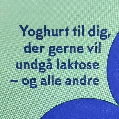 A picture of some Danish text on a carton of yogurt. It says:

“Yoghurt til dig, der gerne vil undgå laktose – og alle andre”

Or in English:

“Yogurt for those who want to avoid lactose – and everybody else”