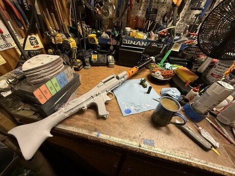 An incomplete DL-19X Star Wars heavy blaster project underway on a very cluttered workbench. More cluttered than usual even, which is saying something!