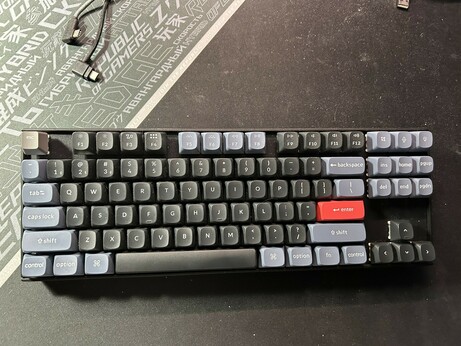 Image of my Keychron K8 Pro keyboard with the original keycaps, slightly shiny in some cases, with a bright orange "Enter" keycap.