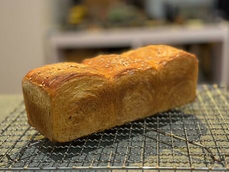 A three domed sandwich loaf on a rack.