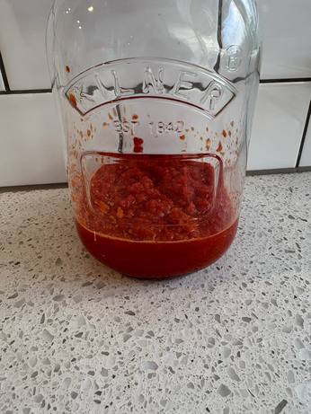 A jar of chilli mash with salt in a fermentation jar