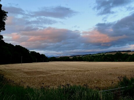 The sun sets in a sky of blue, white and pink