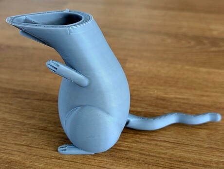 A gray, incomplete 3d print of a standing rat, showing where the printing stopped because the print started sliding around on the bed.