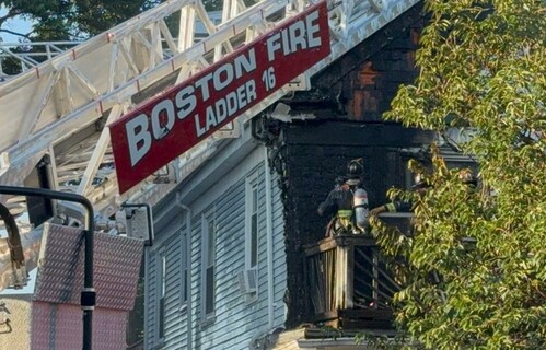 Firefighters on charred porch, photo by Ed Grzyb