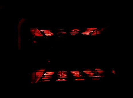 Filaments glow as toast toasts in the toaster, round side down.