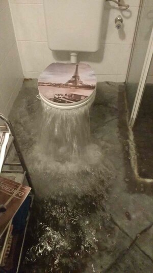 Toilet overflowing- has river and tower embossed on Toilet seat