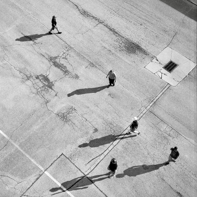 A black and white film photo. Five people can be seen far below during a very sunny day so that it appears that they are mini sundials at the Indycar race at Iowa Speedway in Newton, Iowa. Saturday, July 12, 2025.