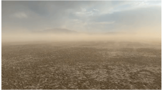 Dust blows off the mud-cracked surface of a dry lake bed, obscuring the blue sky above.  Photo by Kevin Perry, July 9, 2025