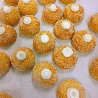 Round buns, sugared with a blob of vanilla cream peaking out.