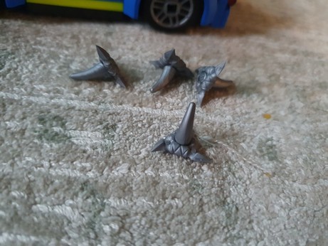 Four grey plastic caltrops.