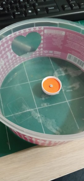 A magnet inside a raft made with a bottle cap flosting in water as a way to check if it is diametrically or axially magnetized